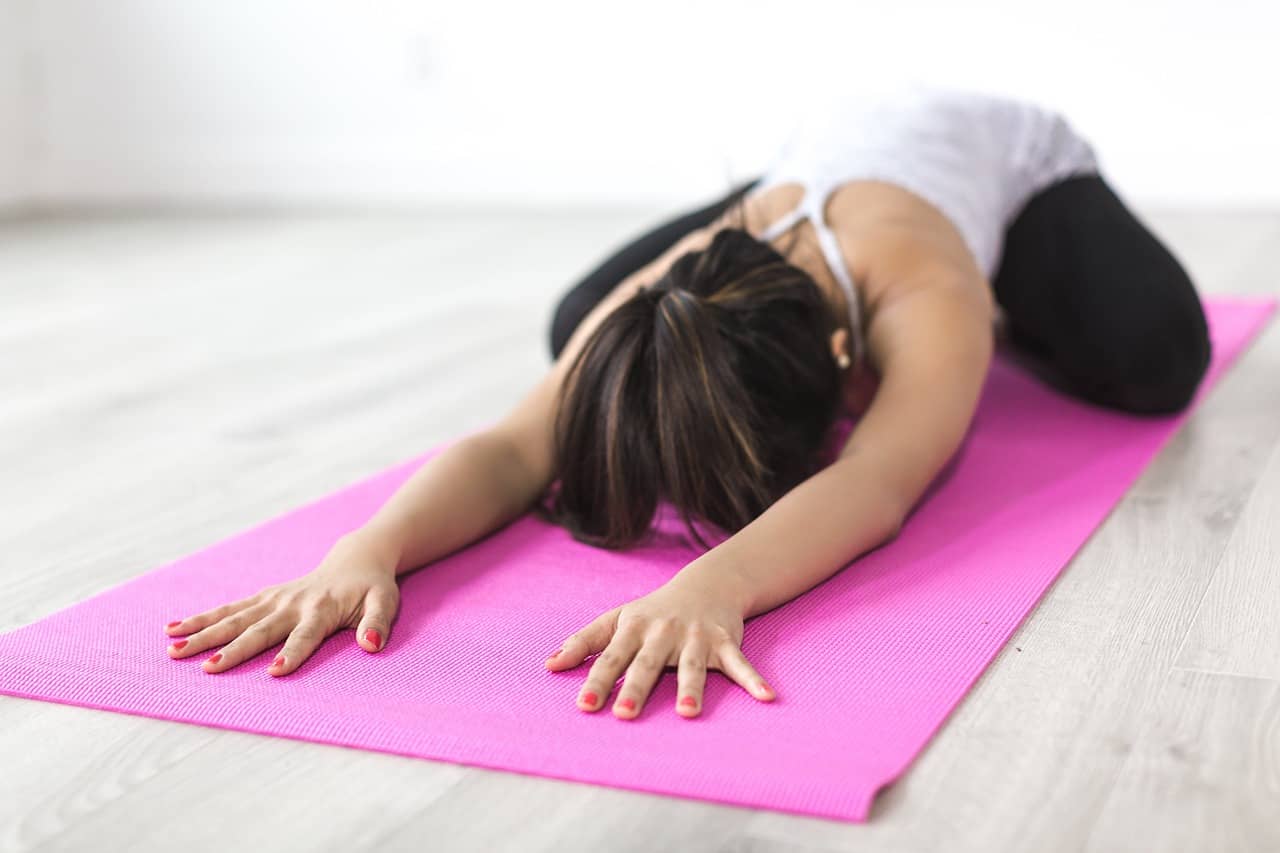 girl stretching on a purple yoga mat